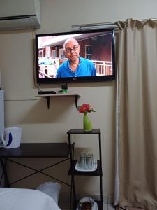 a television on a wall with a man on it at Sheeroh's Place in Burgersfort