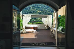 an archway leading to a patio with a table and chairs at THE SECRET SUITE - SUPERIOR "Lago di Endine" in Ranzanico