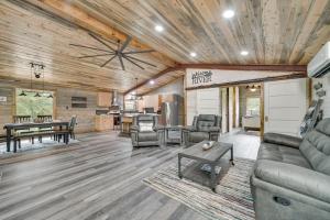 a living room with a couch and a table at Broken Bow Riverfront Cabin with Private Hot Tub! in Broken Bow