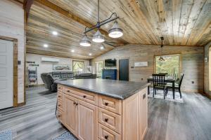a kitchen and living room with a table and chairs at Broken Bow Riverfront Cabin with Private Hot Tub! in Broken Bow