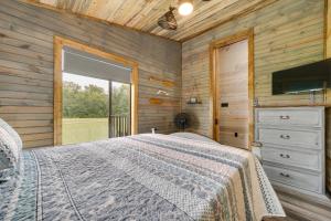 1 dormitorio con cama y ventana grande en Broken Bow Riverfront Cabin with Private Hot Tub! en Broken Bow