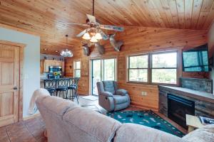 a living room with a couch and a fireplace at Pet-Friendly Iron River Cabin with Fire Pit! in Iron River