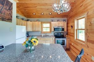 a kitchen with a table with a vase of flowers at Pet-Friendly Iron River Cabin with Fire Pit! in Iron River