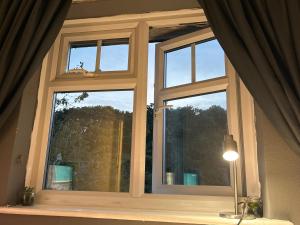 a window in a room with a lamp in front of it at A Home from Home in Redditch near town centre in Redditch