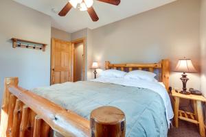 a bedroom with a large wooden bed with blue sheets at Pet-Friendly Iron River Cabin with Fire Pit! in Iron River