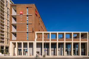 a person riding a bike in front of a building at ibis London Canning Town in London