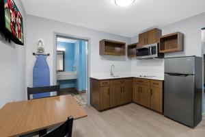 a kitchen with a table and a refrigerator at HomeTowne Studios by Red Roof Orange, TX in Orange +51 photos