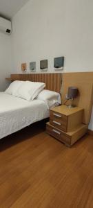1 Schlafzimmer mit 2 Betten und einem Nachttisch mit einem Schreibtisch in der Unterkunft Apartamento Torres19 in Sevilla