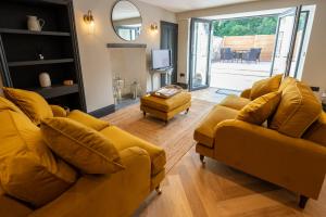 Sala de estar con 2 sofás amarillos y TV en Siabod - Snowdonia, North Wales, en Bethesda