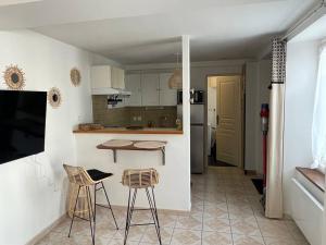 a kitchen with a table and two chairs and a counter at L’escapade Balnéo, Centre ville in Sens