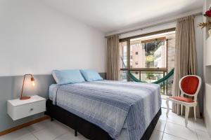 ein Schlafzimmer mit einem Bett und einem großen Fenster in der Unterkunft Jacuzzi Privativa Cobertura no coração de Itaipava in Itaipava