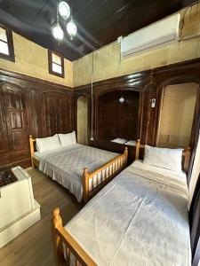two beds in a room with wooden walls at Hayadlı Konak Butik Otel in Gaziantep