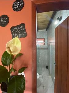 een badkamer met een plant en een bord op de muur bij FLAT 2 QUARTOS PITUBA - ITACARÉ-Ba in Itacaré