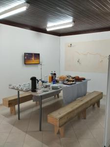 una mesa y bancos en una habitación con comida. en HOSTEL CAMINHO DA FE, en Aparecida