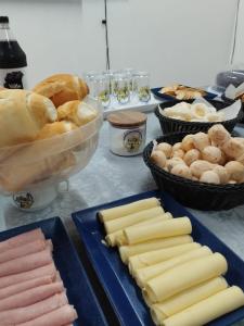 una mesa cubierta con platos de queso y pan en HOSTEL CAMINHO DA FE, en Aparecida