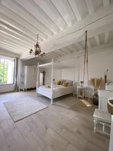 1 dormitorio con cama blanca y techo blanco en LE SAINT LEONARD, en Montceaux-lès-Provins