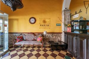 a lobby with a couch and a clock on the wall at Hotel Santiago in Mérida