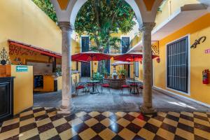 a courtyard with tables and umbrellas in a building at Hotel Santiago in Mérida