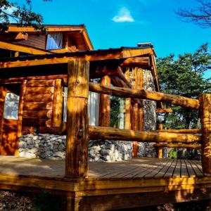 a wooden deck in front of a log cabin at El Rincon de Pehuenia in Villa Pehuenia