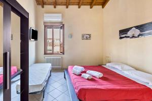 a bedroom with a red bed with two towels on it at House Verona in Verona +49 photos