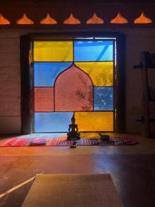 ein Buntglasfenster mit einem Bett davor in der Unterkunft Shanti - Hospedaria na Vila de São Jorge in Sao Jorge