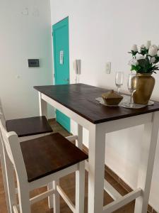 une table à manger avec deux chaises et un vase fleuri dans l'établissement EDIFICIO REY NIÑO, à Posadas