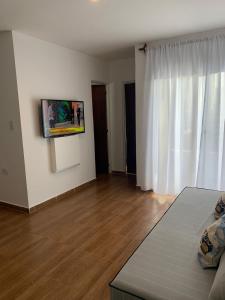 EDIFICIO REY NIÑO في بوساداس: غرفة معيشة مع أريكة وتلفزيون على جدار