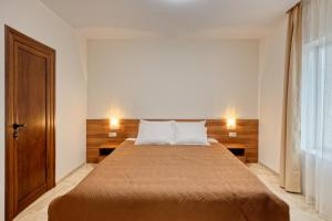 1 dormitorio con 1 cama con 2 almohadas en Къща за гости Relax, en Hisarya