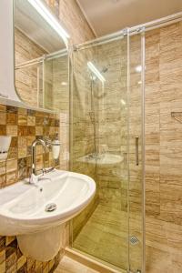 La salle de bains est pourvue d'un lavabo et d'une douche en verre. dans l'établissement Къща за гости Relax, à Hisarya