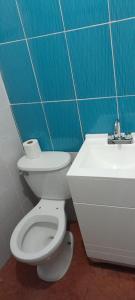 a bathroom with a white toilet and a sink at Bonito y práctico departamento. in Ixmiquilpan