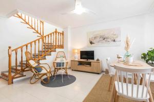 sala de estar con escalera, mesa y sillas en Kuthana Rentals Duplex Copacabana en primera línea, en La Manga del Mar Menor