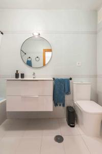 y baño con lavabo, aseo y espejo. en Kuthana Rentals Duplex Copacabana en primera línea, en La Manga del Mar Menor