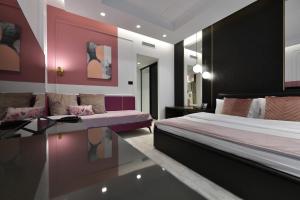 una camera da letto con un letto, un divano e un tavolo di Royal Wellness and Spa a Ruma