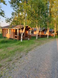 una cabaña de madera con una carretera delante de ella en Pahkalanniemi Camping en Parkano