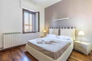 a white bedroom with a large bed and a window at House Verona Zen in Verona