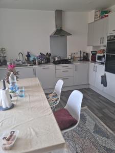 a kitchen with a table and chairs and a stove at large room for 2 sofa and TV in Newhaven