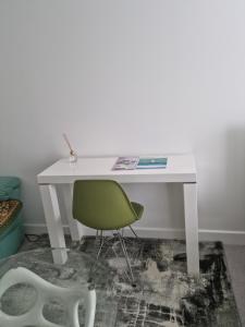 a white desk with a green chair in a room at large room for 2 sofa and TV in Newhaven