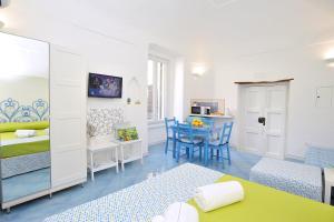 een kamer met een bed en een tafel en stoelen bij CASETTAZZURRA in Amalfi