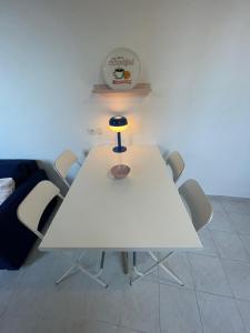 une table blanche avec des chaises et une lampe sur celle-ci dans l'établissement Patio de la pietonne, à Menton