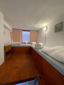 two beds in a small room with a window at Patio de la pietonne in Menton