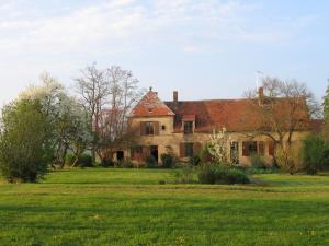 an old house in a field of green grass at Gîte Le Tremblay in Thianges