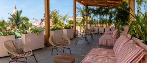 eine Terrasse mit Stühlen, Tischen und Pflanzen in der Unterkunft La Passion by Masaya in Cartagena de Indias