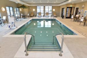 a pool in a hotel with stairs leading to a restaurant at Hampton Inn & Suites Chippewa Falls in Chippewa Falls