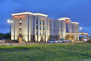 a large hotel with cars parked in front of it at Hampton Inn & Suites Chippewa Falls in Chippewa Falls