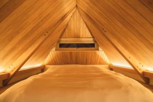 a room with a bed in a wooden cabin at The Nest 弟子屈 in Teshikaga