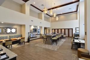 Hampton Inn & Suites Chippewa Falls في شبوا فولز: غرفة طعام مع طاولات وكراسي في مطعم