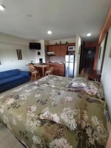 a bedroom with a large bed and a kitchen at Esparta Suite isla de margarita in Porlamar