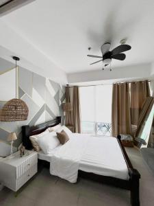 a bedroom with a white bed and a ceiling fan at Azure Urban Beach Resort by Melrose Avenue in Manila