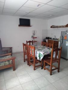 cocina con mesa, sillas y nevera en Alojamiento Temporarios NEA en Formosa