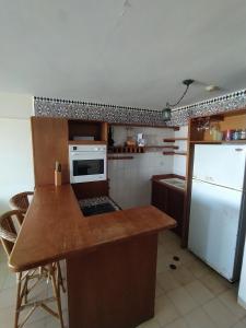a kitchen with a counter and a white refrigerator at Esparta Suite isla de margarita in Porlamar